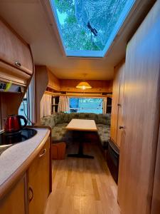 a kitchen with a table in the middle of a trailer at Kanukamp, Kemping nad rzeką in Tarnogóra