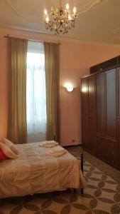sypialnia z dużym łóżkiem i żyrandolem w obiekcie Royal Suite w Genui