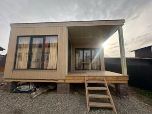 a tiny house on a platform with a ladder at EL House in Karakol +2 photos