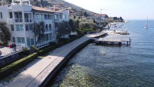 a body of water next to a building with houses at Juwel am See in Castelletto di Brenzone