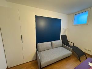 a living room with a couch and a chair at Juwel am See in Castelletto di Brenzone +4 photos