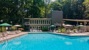 a swimming pool with chairs and umbrellas in front of a building at Bears Among Us in Gatlinburg