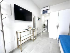 a room with a desk and a tv on a wall at La Pola House Cagliari in Cagliari