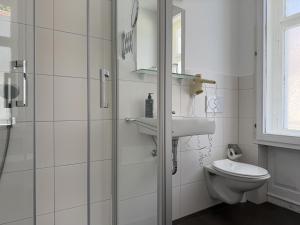 a bathroom with a toilet and a sink and a shower at Hotel TheCorner in Konstanz