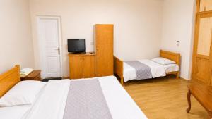 a small room with two beds and a tv at Tuz House R5 in Bakuriani