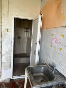 a dirty bathroom with a sink and a shower at Budget Room Vilnius in Vilnius