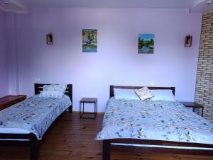 two beds in a bedroom with blue walls at Фазенда in Bohuslav