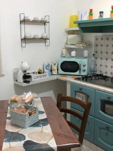 a kitchen with a table and a blue microwave at Donna Teresa in Castelbuono