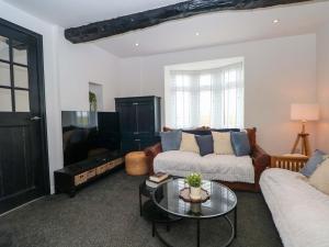 a living room with a couch and a tv at Broad Beams in Neston