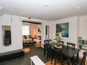 a dining room and living room with a table and chairs at Broad Beams in Neston