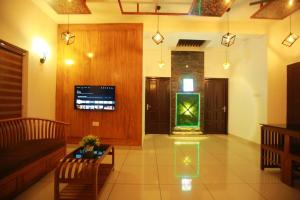 a living room with a couch and a green aquarium at AJ Homes - Aaron Villa in Ernakulam