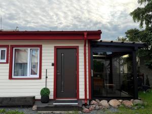 a red and white house with a black door at Pärnu Summer Studio in Pärnu +3 photos