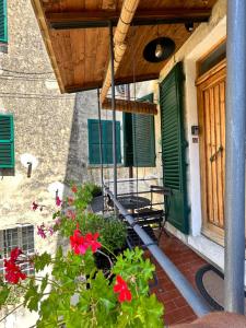 a porch with a green door and some flowers at Corte Bargagli, dolce casa in palazzo toscano in Sarteano +16 photos