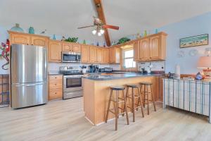 a kitchen with wooden cabinets and a stainless steel refrigerator at 5070 - Sandy Bottoms in Kill Devil Hills