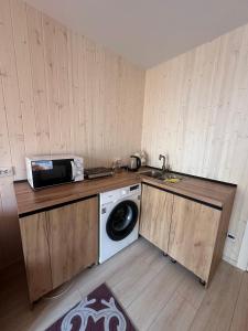 a kitchen with a washing machine and a microwave at EL House in Karakol