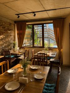 a restaurant with wooden tables and chairs and windows at Relax Kazbegi Panoramic Mountain View in Kazbegi +94 photos