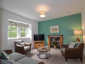 a living room with a couch and chairs and a tv at Station Lodge in Forres