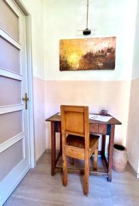 a wooden table with a chair and a painting on the wall at Corte Bargagli, dolce casa in palazzo toscano in Sarteano