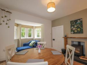 a living room with a table and a blue couch at Station Lodge in Forres