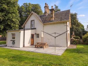 a house with a picnic table in the yard at Station Lodge in Forres