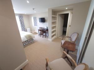 a bedroom with a bed and a chair and a table at The Fox at Ibstone in High Wycombe