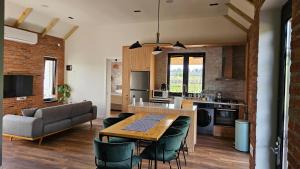 a kitchen and living room with a table and chairs at Villa Lazarina Vineyard Views in Kvareli