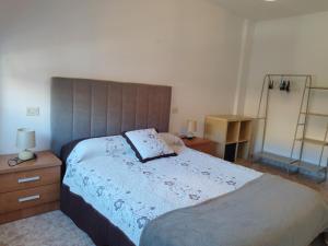 a bedroom with a large bed with a wooden headboard at Vivienda 2 sin ascensor in Laxe
