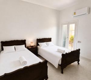 two beds in a white room with a window at Charming 3BDR Chalet l North Coast in Dawwār Muşādif Yūnus +30 photos