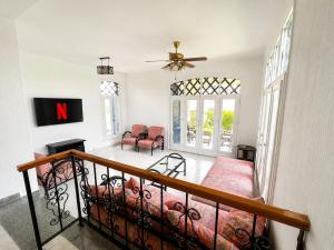 a living room with a staircase with a couch and a fan at Charming 3BDR Chalet l North Coast in Dawwār Muşādif Yūnus
