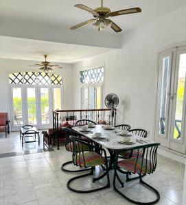 a living room with a table with chairs and a ceiling fan at Charming 3BDR Chalet l North Coast in Dawwār Muşādif Yūnus