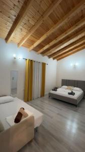 two beds in a large room with wooden ceilings at apartment Himara SkyView in Himare
