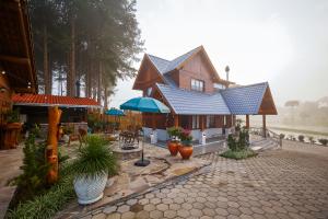 a house with a blue roof and some plants at Hospedaria Morada das Grimpas in Palmeira