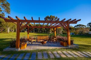 a wooden pergola with benches and tables in a park at Hospedaria Morada das Grimpas in Palmeira +57 photos