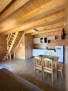 a kitchen with a table and chairs in a cabin at Domki Prima Baltic in Sarbinowo