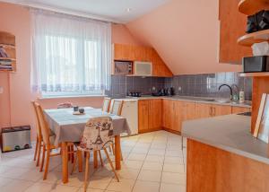 a kitchen with a table and chairs and a table and a kitchen at MM Pokoje in Dziwnówek