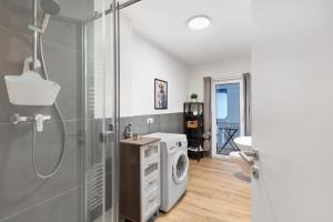 a bathroom with a shower and a washing machine at Ferienhaus Bühlertal mit 3 Fewos in Bühlertal