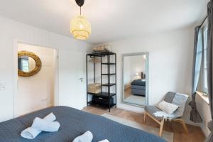a bedroom with a bed and a mirror and a chair at Ferienhaus Bühlertal mit 3 Fewos in Bühlertal