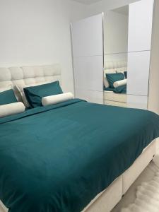 a bedroom with a large bed with blue sheets and mirrors at Villa Nova Bar in Bar +23 photos