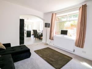 a living room with a couch and a window at Lucerne Cottage in Dorking