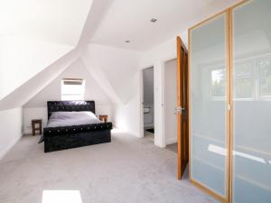 a bedroom with a bed in a attic at Lucerne Cottage in Dorking