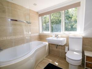 a bathroom with a tub and a toilet and a sink at Lucerne Cottage in Dorking +26 photos