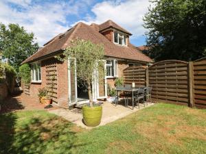 a small house with a tree in a yard at Lucerne Cottage in Dorking