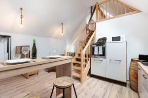 a kitchen with a wooden table and a white refrigerator at Ferienhaus Bühlertal mit 3 Fewos in Bühlertal