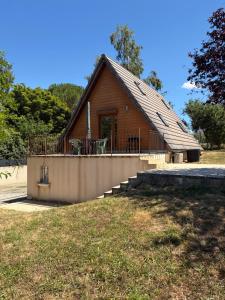 a small cabin with a porch and a deck at Chalet 6 à 8 personnes in Drulhe