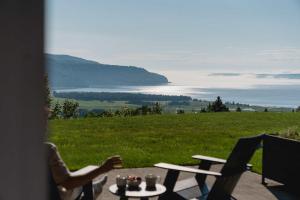 a table and chairs with a view of a lake at 102 - Upscale Condo - River View Terrace in Baie-Saint-Paul