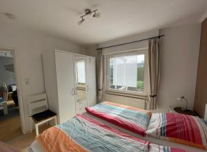 a bedroom with a bed and a window at Ferienhaus Wind & Welle in Norddeich