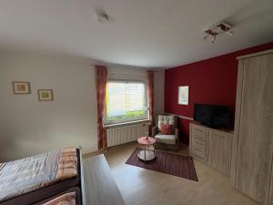 a living room with a couch and a television at Ferienhaus Wind & Welle in Norddeich