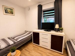 a bedroom with a bed and a television on a dresser at Rent Room Vermietungen in Oberhausen