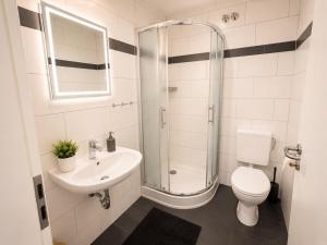 a bathroom with a toilet and a sink and a shower at Rent Room Vermietungen in Oberhausen +11 photos