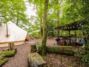 a tent and a picnic table in a forest at The Moroccan Bell Tent in Newbury